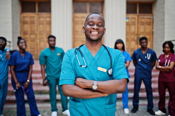 Group of african medical students posed outdoor against university door.